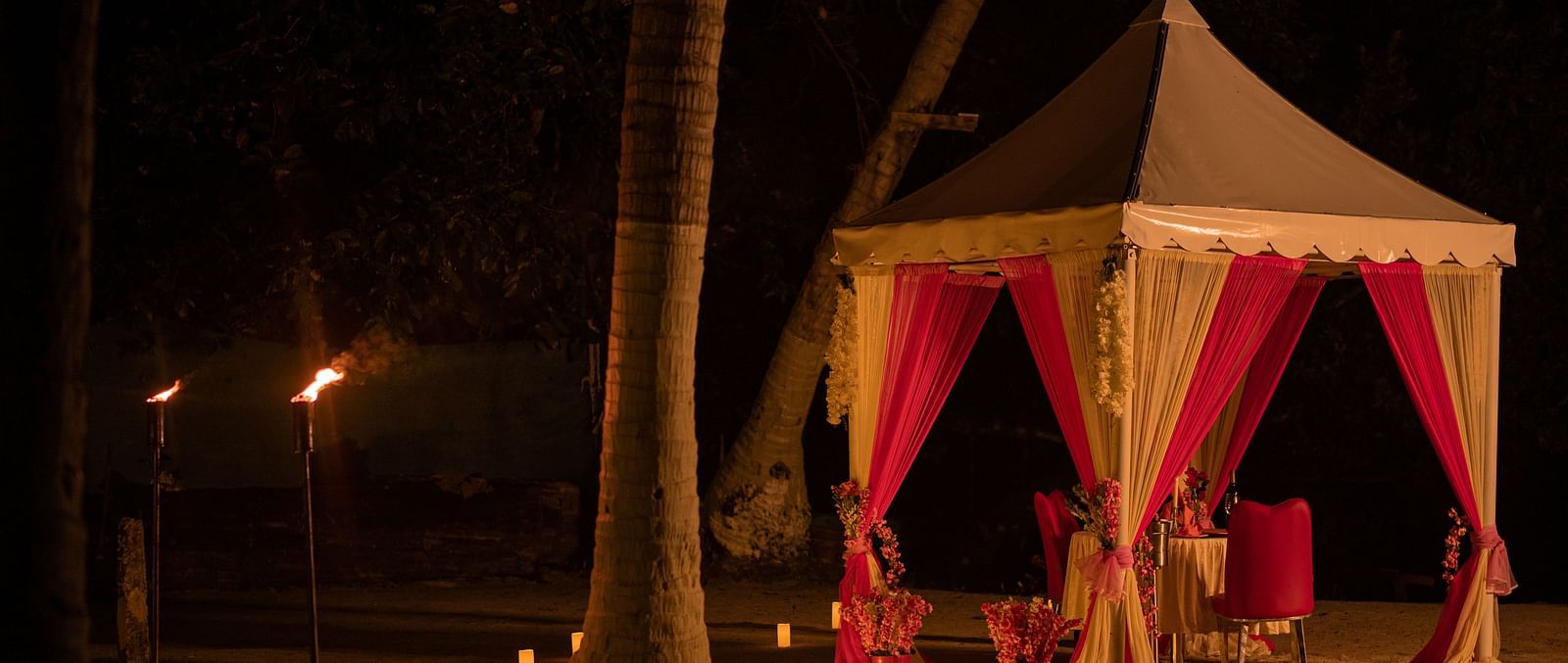 A romantic beachfront canopy lit by torches and candles at night - Coral Reef Resort & Spa, Havelock