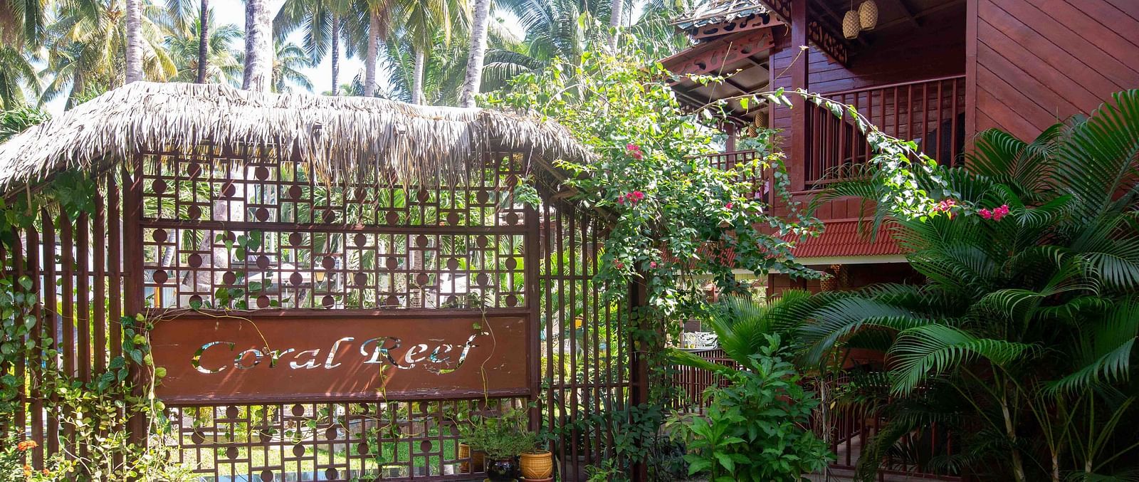 A close-up view of the resort’s garden area, with lush greenery and palm trees framing the space. The tropical surroundings add to the peaceful atmosphere - Coral Reef Resort & Spa, Havelock