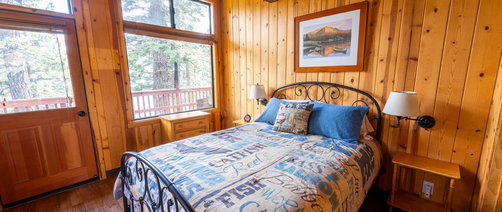 Sunlit bedroom with wooden walls and quilted bedspread at Kit Carson Lodge.