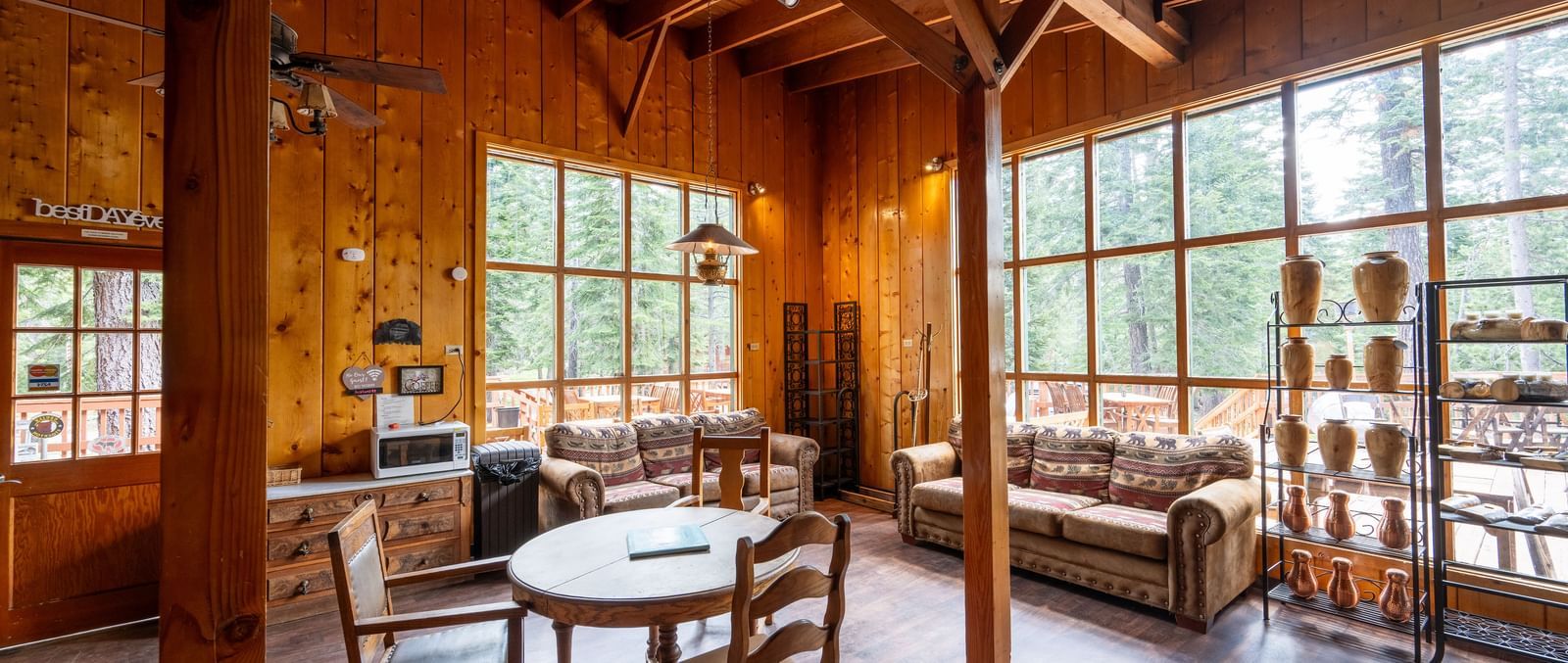 Cozy wood-paneled lounge area with large windows and rustic seating inside Kit Carson Lodge.