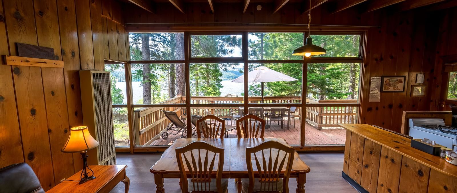 Cabin dining area with large windows offering forest views at Kit Carson Lodge.