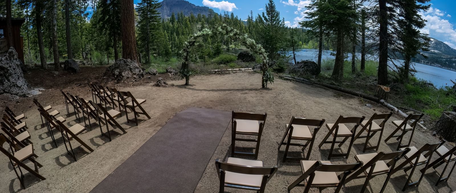 Outdoor ceremony setup with wooden chairs and forest views at Kit Carson Lodge.