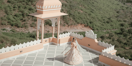 The newly wed couple dancing on a terrace of Fateh Vilas, Udaipur surrounded by green hills.