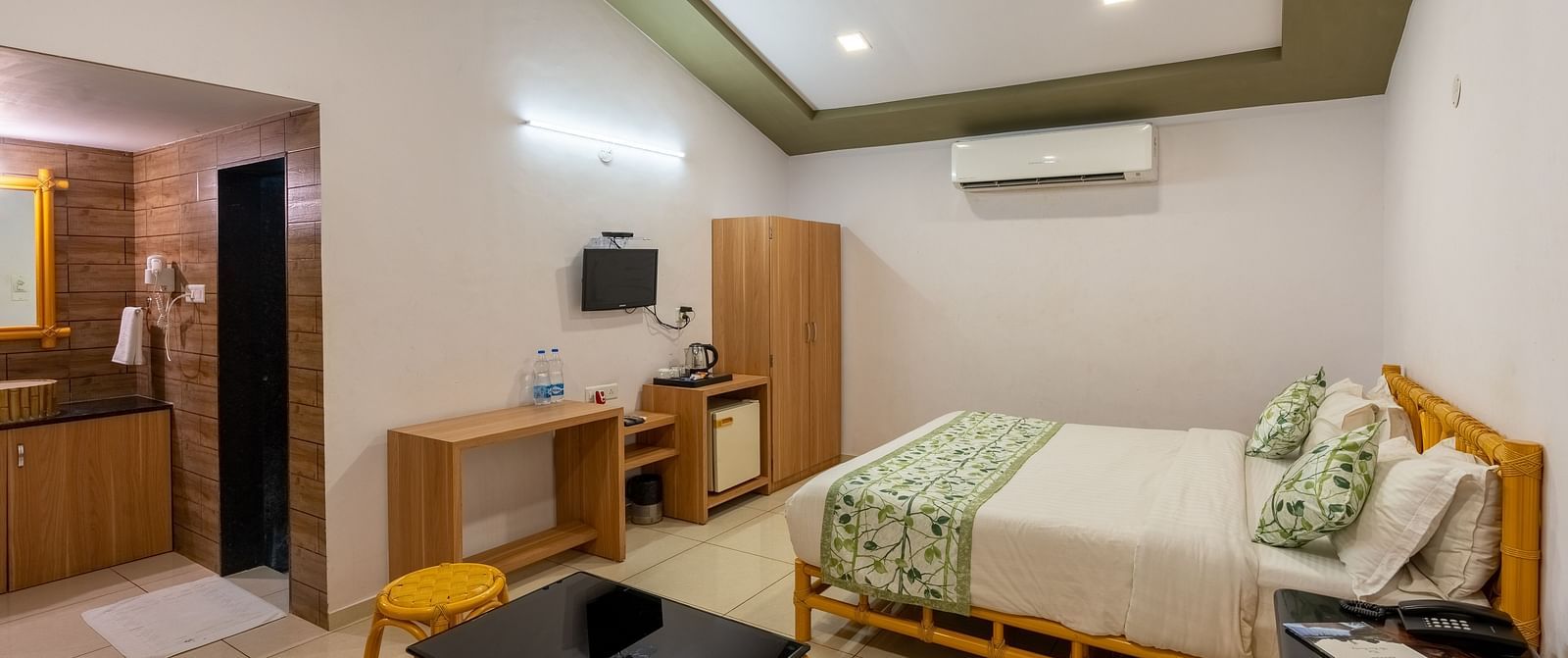 A room with a double bed, seating arrangement and work desk and chair