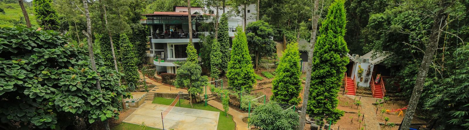 Aerial view of a swimming pool with tress surrounding it at WOW Bison Woods.