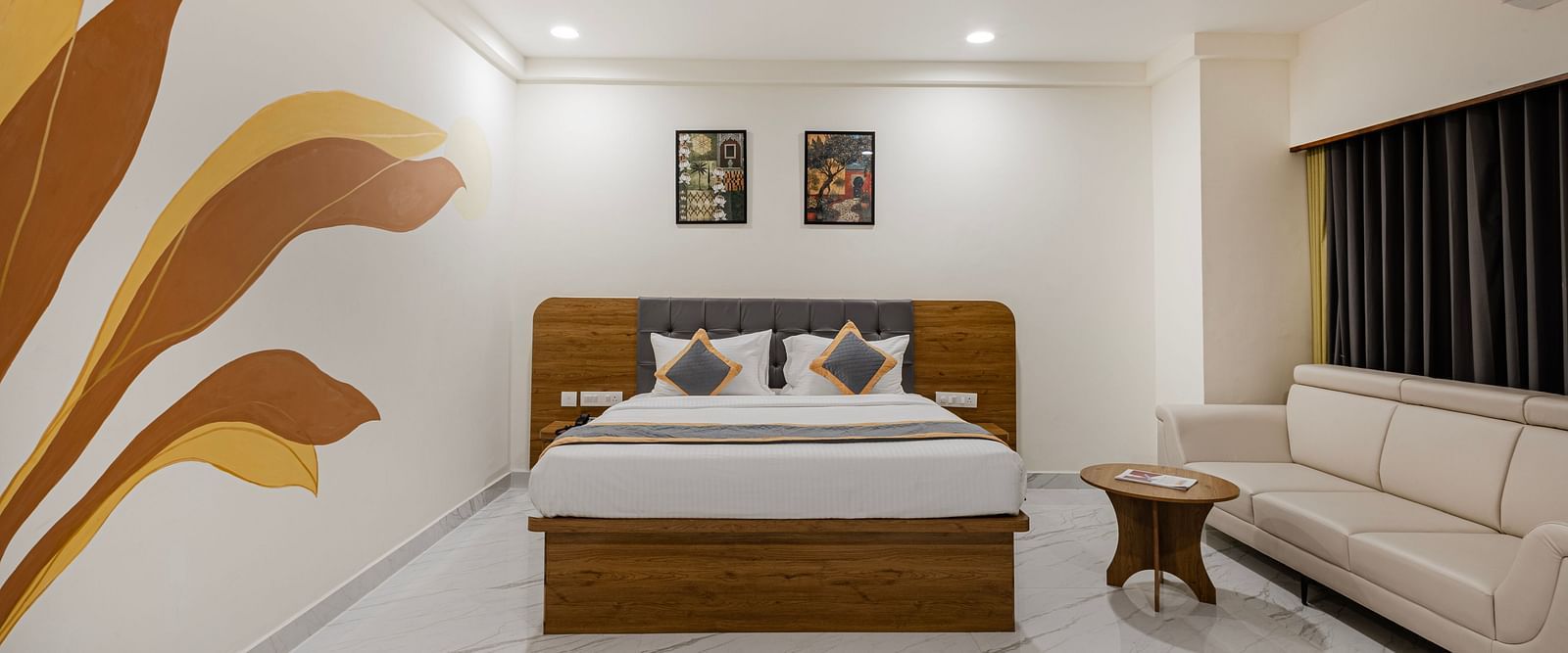 Corner view of a premium room with sofa, artwork, and ambient lighting at Lemonridge Hotels, IDPL Balanagar.