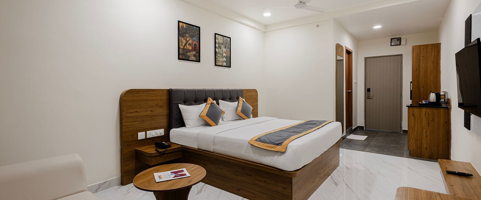 Spacious room with wooden furniture and minimalist décor at Lemonridge Hotels, IDPL Balanagar.