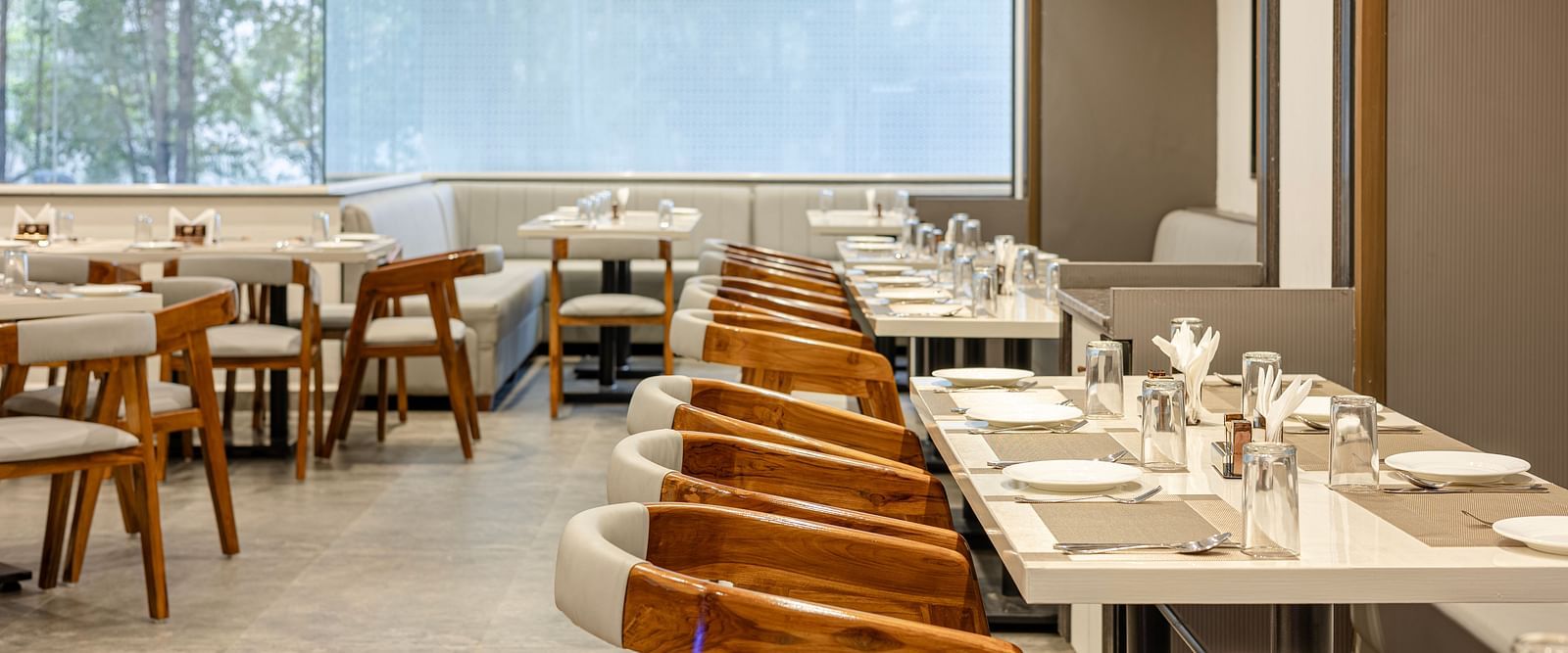 A close view of the modern dining space with natural light at Lemonridge Hotels, IDPL Balanagar