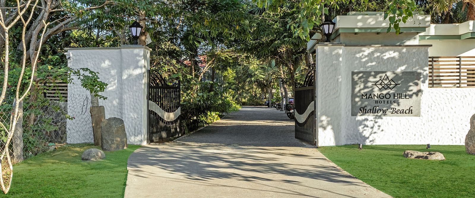 Resort entrance gate with a pathway leading through lush greenery to the Pondicherry wedding resorts | Mango Hill Shallow Beach Resort ECR