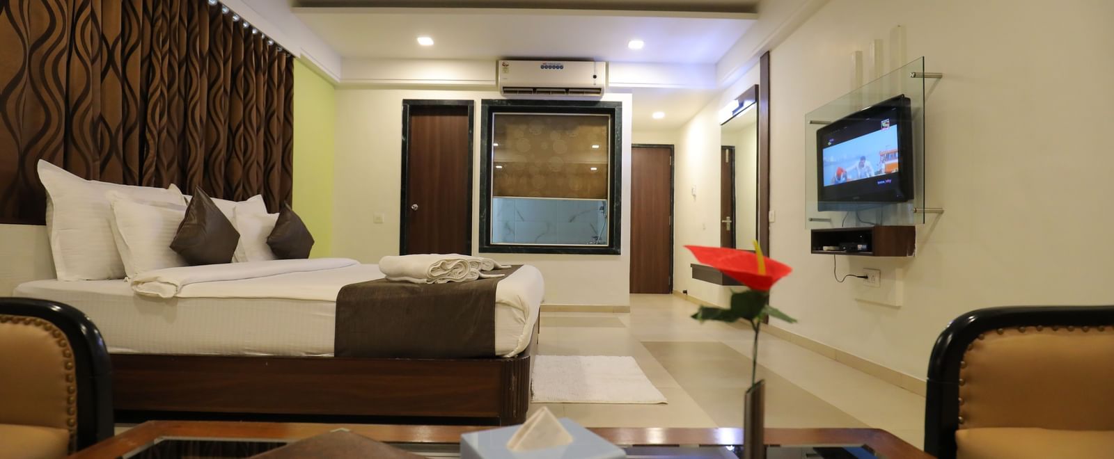 A bedroom at Krushnai Resort featuring a large bed, a TV, and modern interiors.