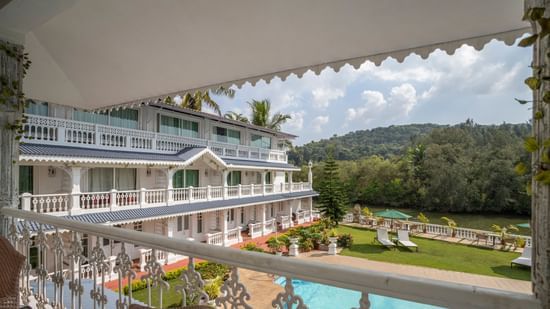 The Maharaja Balcony offers a splendid view of the facade, pool and thick vegetation surrounding the premise - Stone Wood Riverfront Resort, Siolim