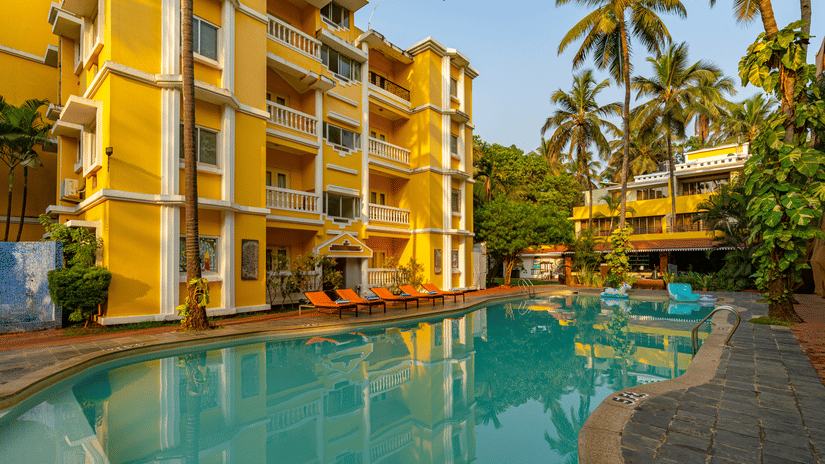 The pool of the hotel surrounded by the hotel building.