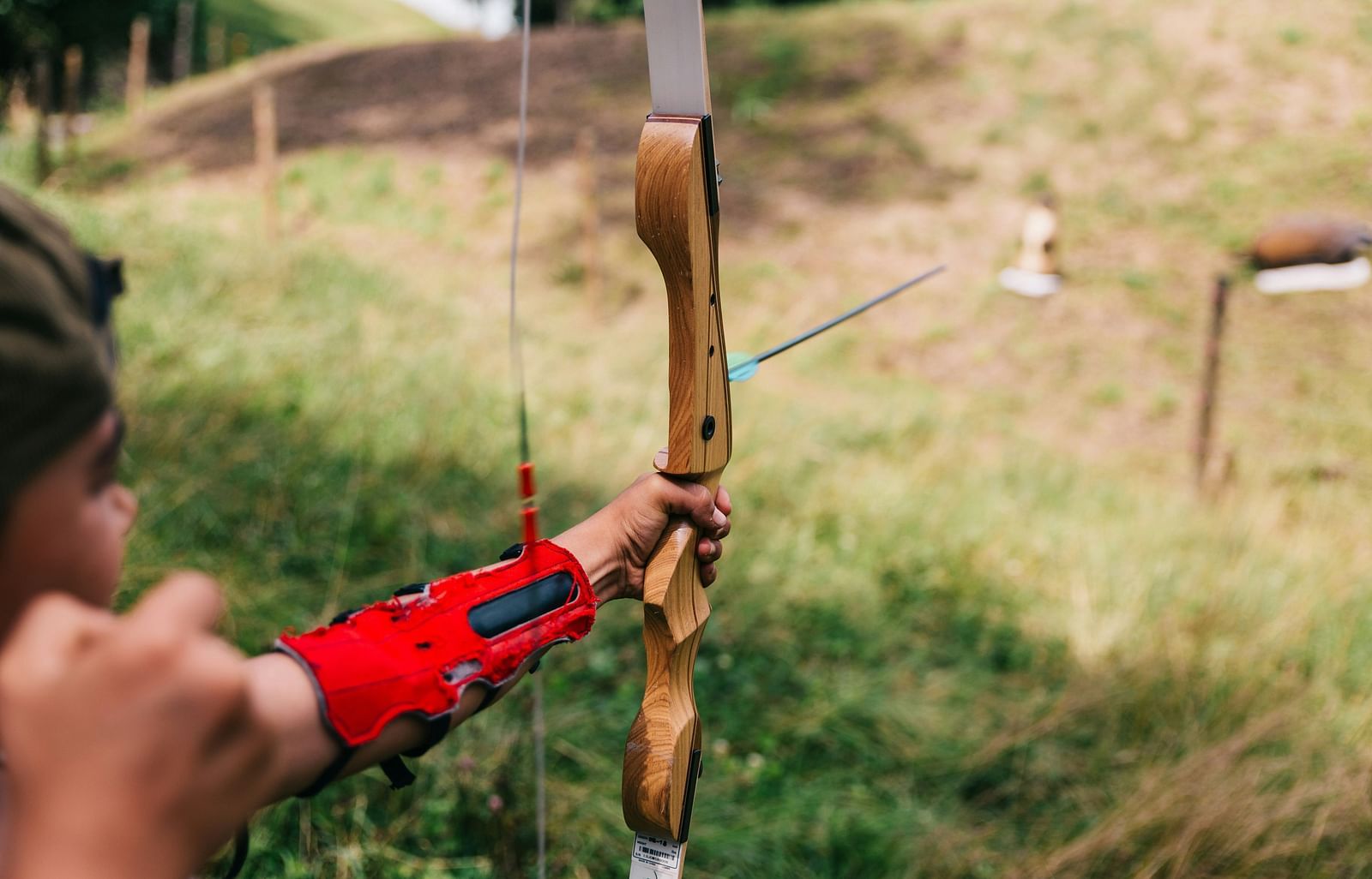 A child practicing archery in an open field.