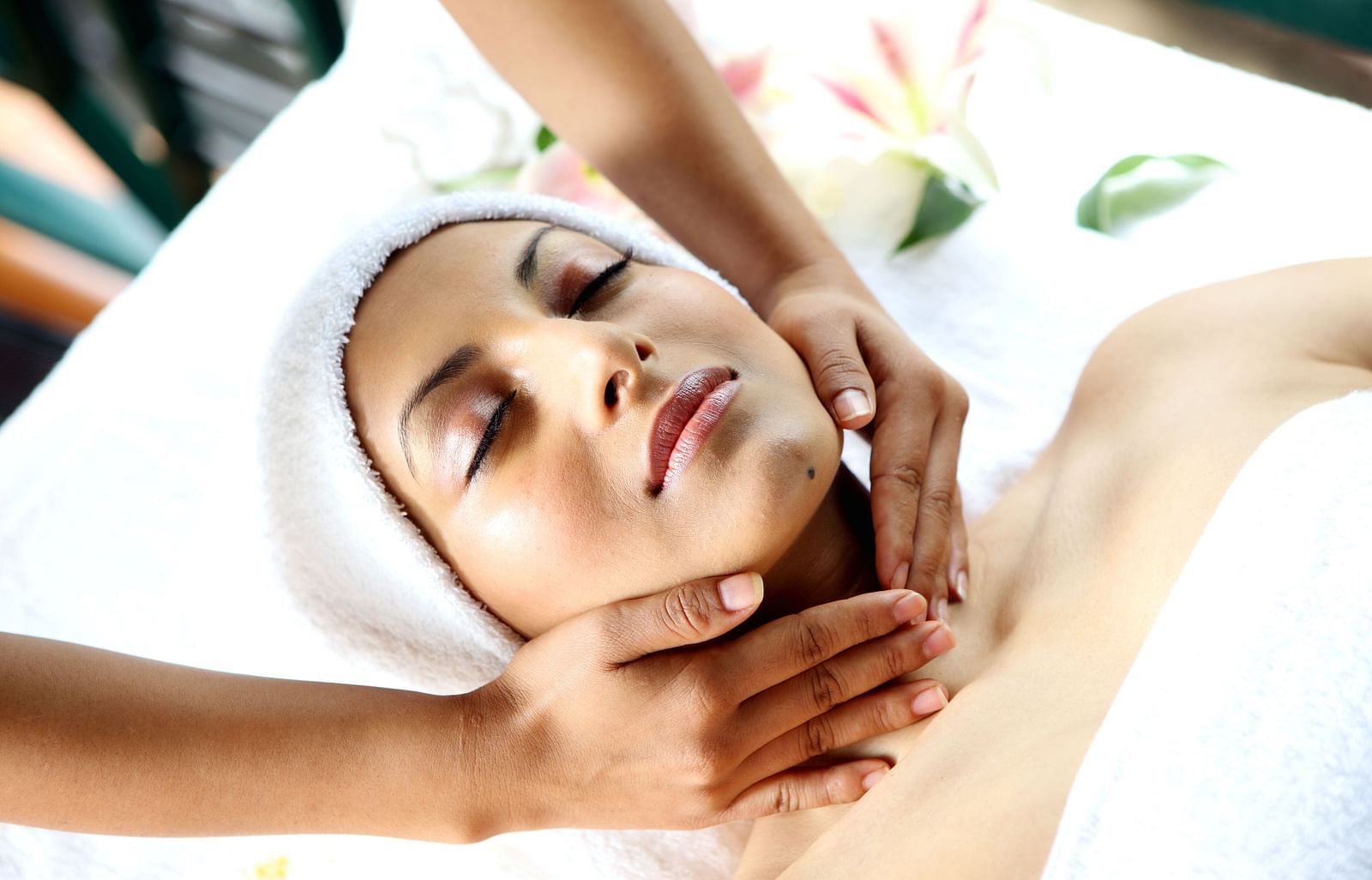 A women is relaxing and having facial massage done.