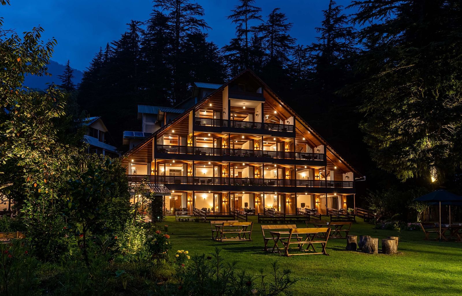 An image of a well lit facade of Bedzzz Xclusiv Baikunth, Manali at during the night time