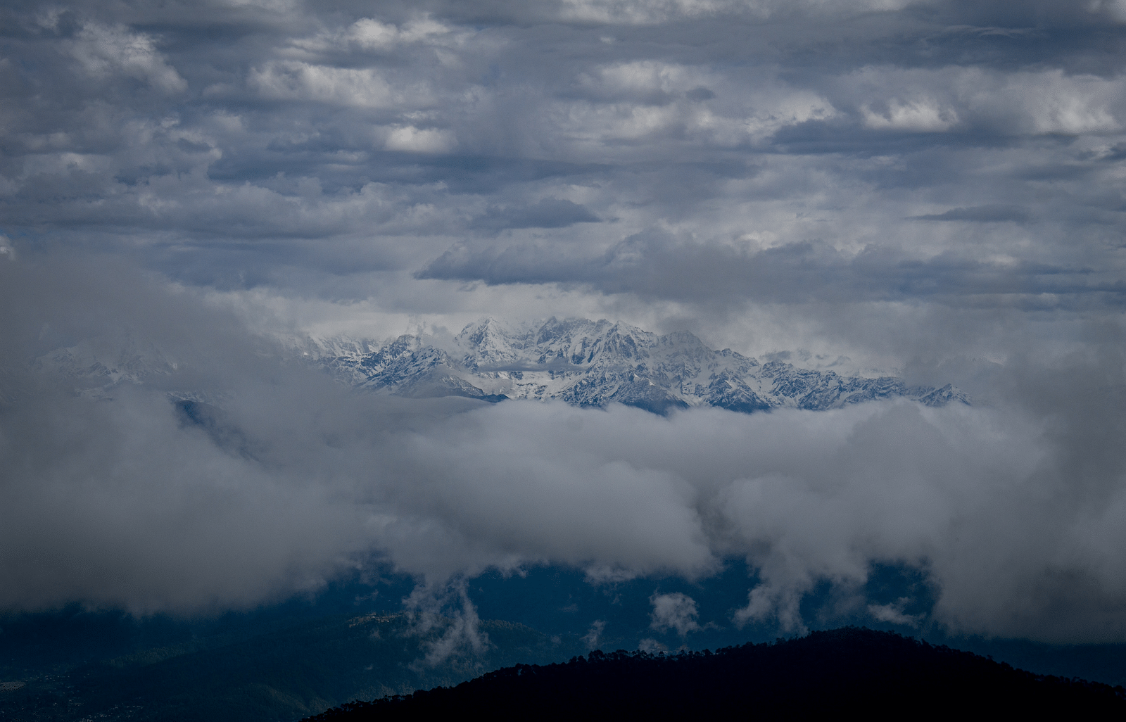 Picture of clouds on top of mountain captured in day light.
