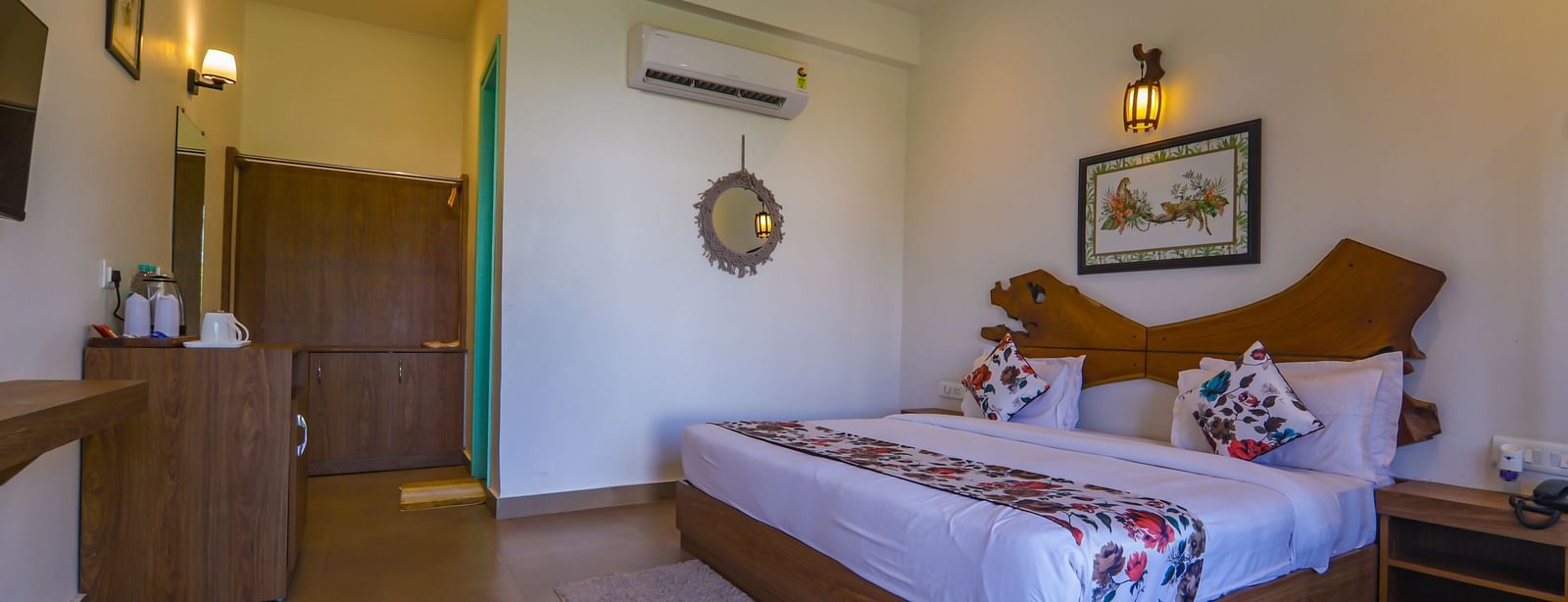 Room at Vedikant Resorts The Mallard Corbett with wooden flooring, modern furniture, bed, wardrobe, and attached bathroom area.