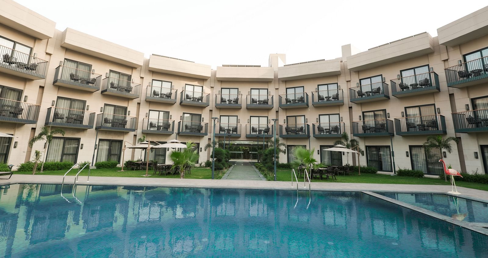 Poolside view with balcony rooms surrounding the courtyard at Ramada by Wyndham Sonipat Murthal