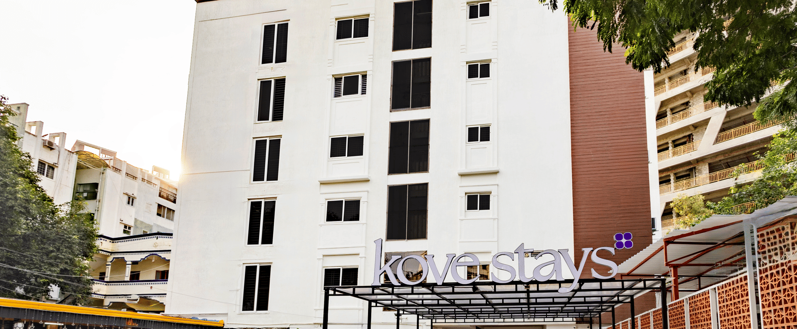 Facade of Kove Smat Stays seen during the day, highlighting its multi-storey building, entryway and extended portico.