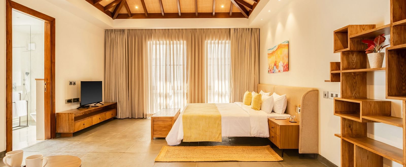 A luxurious bedroom showcasing a warm wooden ceiling, a comfortable bed, and modern furnishings with ample natural light - BluSalzz Villas - Alocassia, Anjuna