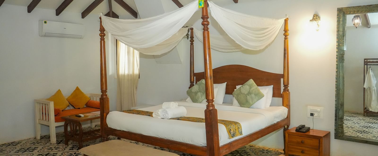 A room with a four-poster bed and seating area at at De Soul Santé, Morjim.