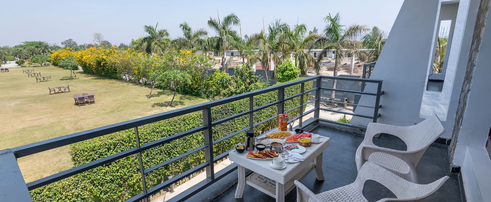 Private balcony setup with chairs and table overlooking open landscape - DLS Forest Vines Resort & Spa, Ramnagar (Jim Corbett)