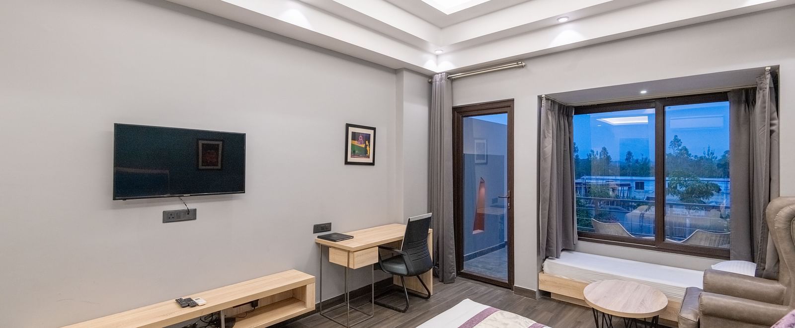 Room with double bed, work desk, and TV, featuring a view outside - DLS Forest Vines Resort & Spa, Ramnagar (Jim Corbett)