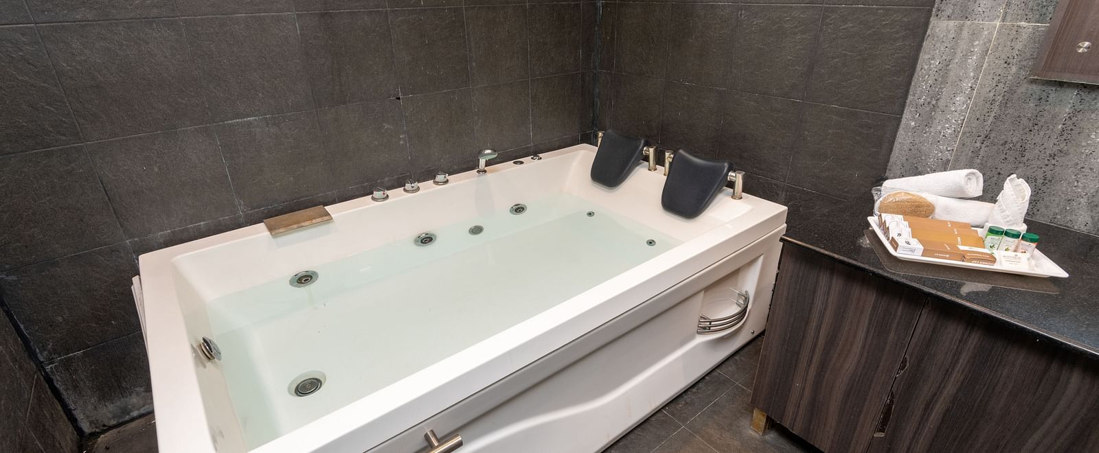 Jacuzzi bathtub beside a towel rack and toiletry tray - DLS Forest Vines Resort & Spa, Ramnagar (Jim Corbett)