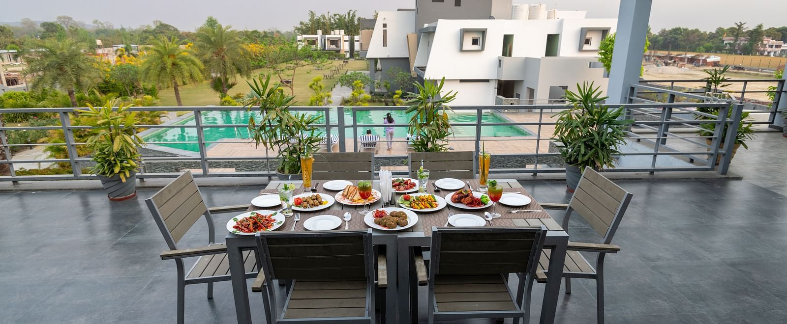 A table for six set with a variety of dishes on the terrace at DLS Forest Vines Resort.