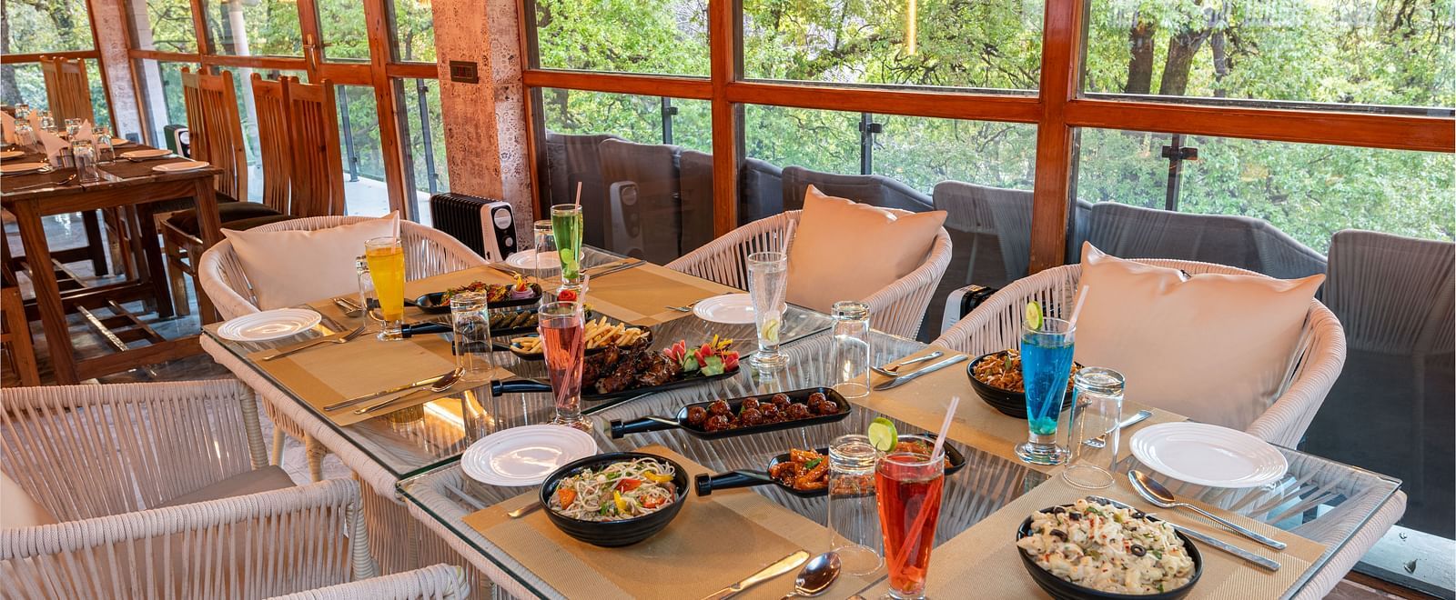 An image of the restaurant chairs and tables with food platters laid on it - DLS The Emerald, Nainital