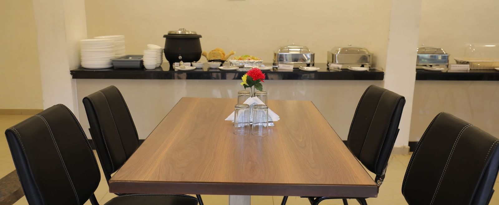 Close up of a dining table at Darbar Restaurant, with the buffet section in the background.
