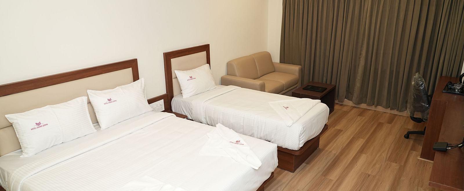 a top view angle of a room with wooden flooring featuring a double bed along with a single bed right beside it - Hotel Grand Sigma