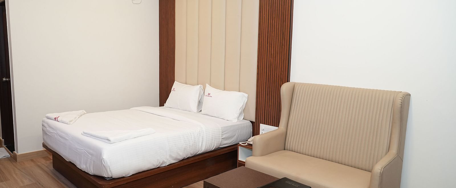 corner view image of the premium executive room with a plush double bed along with a common seating area - Hotel Grand Sigma