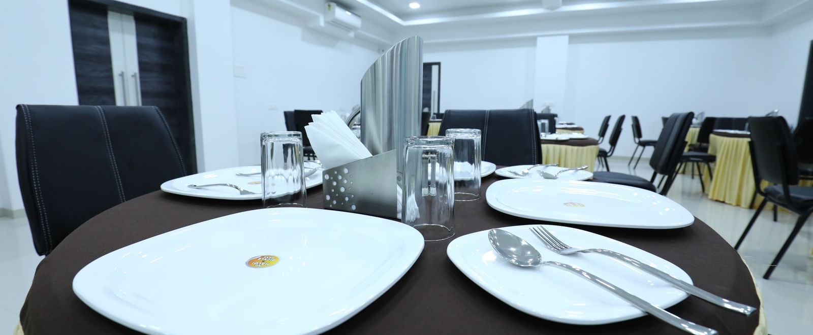 A dining space at Imperial Grande, featuring a round dining table with cutlery set on it.