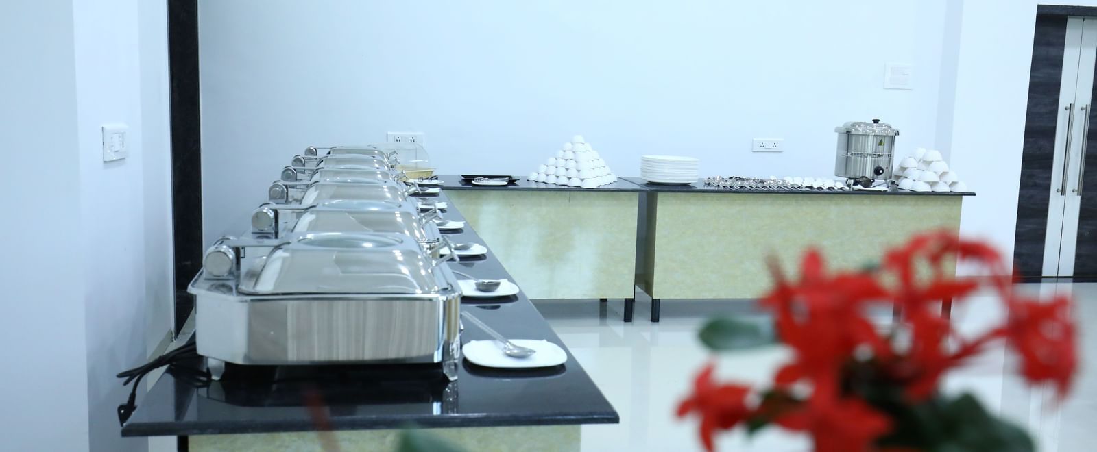 A dining space at Imperial Grande featuring a neatly set buffet counter, shot with a flower in the frame.