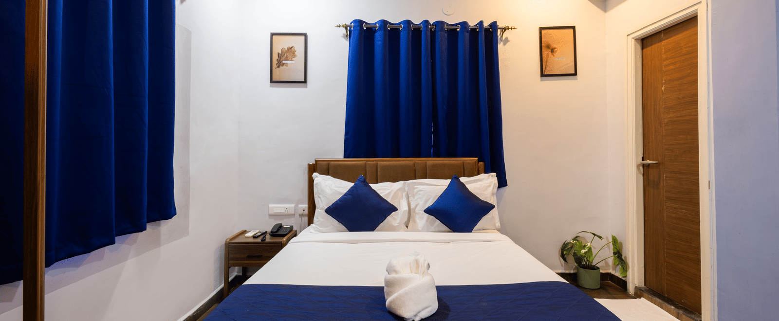 Deluxe Room seen from the foot of the queen size bed placed centrally in the room.