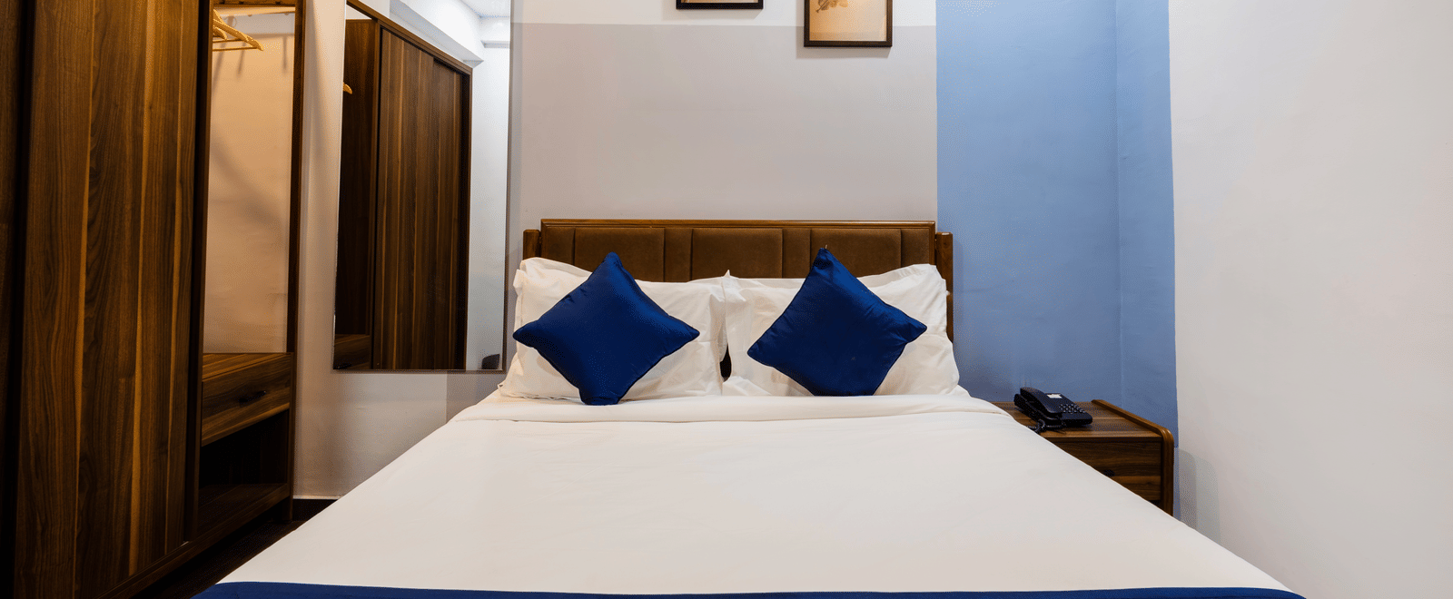 Studio Room's queen size bed seen from the foot of the bed | Kove Smart Stays