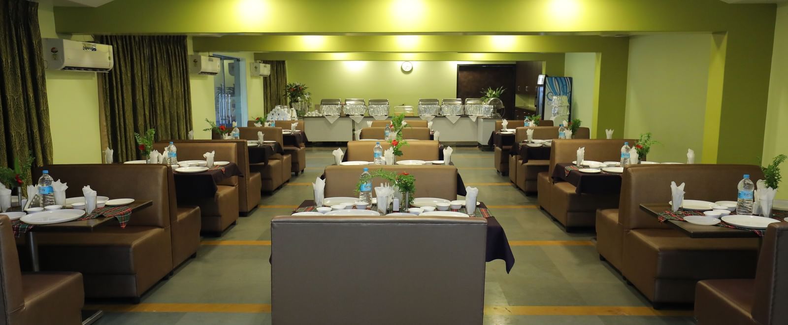 Multiple dining tables arranged in rows at Krushnai Resort restaurant.
