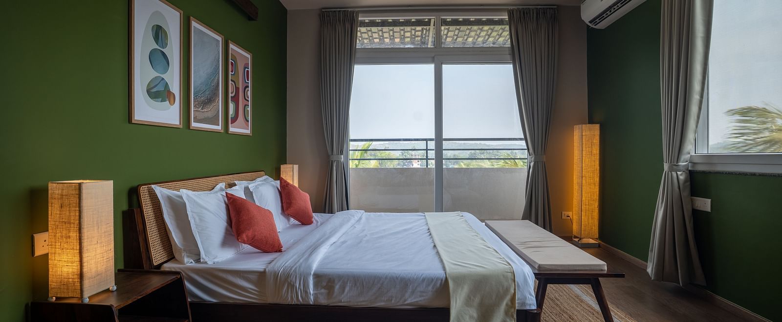 A bedroom with a double bed, bedside lamps, and green accent walls at Kssemya.