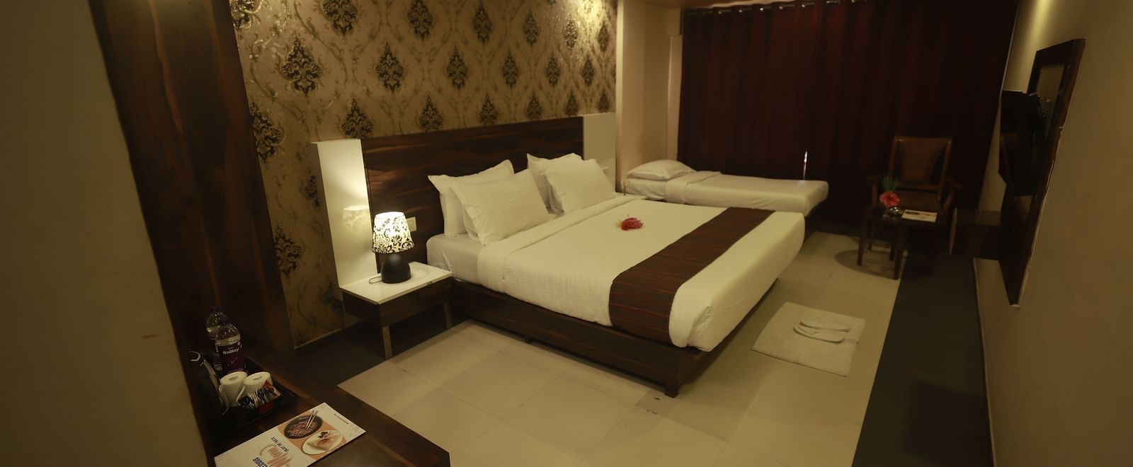 Corner view of the Deluxe Room at Mountview Resort which feature a king size bed, a wardrobe, and wall-mounted TV.