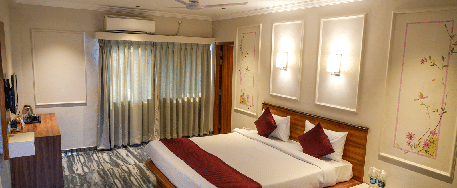  A well-designed deluxe bedroom with striking black and white patterned flooring and recessed wall lights at Pravasa Hotel, Kolhapur. 