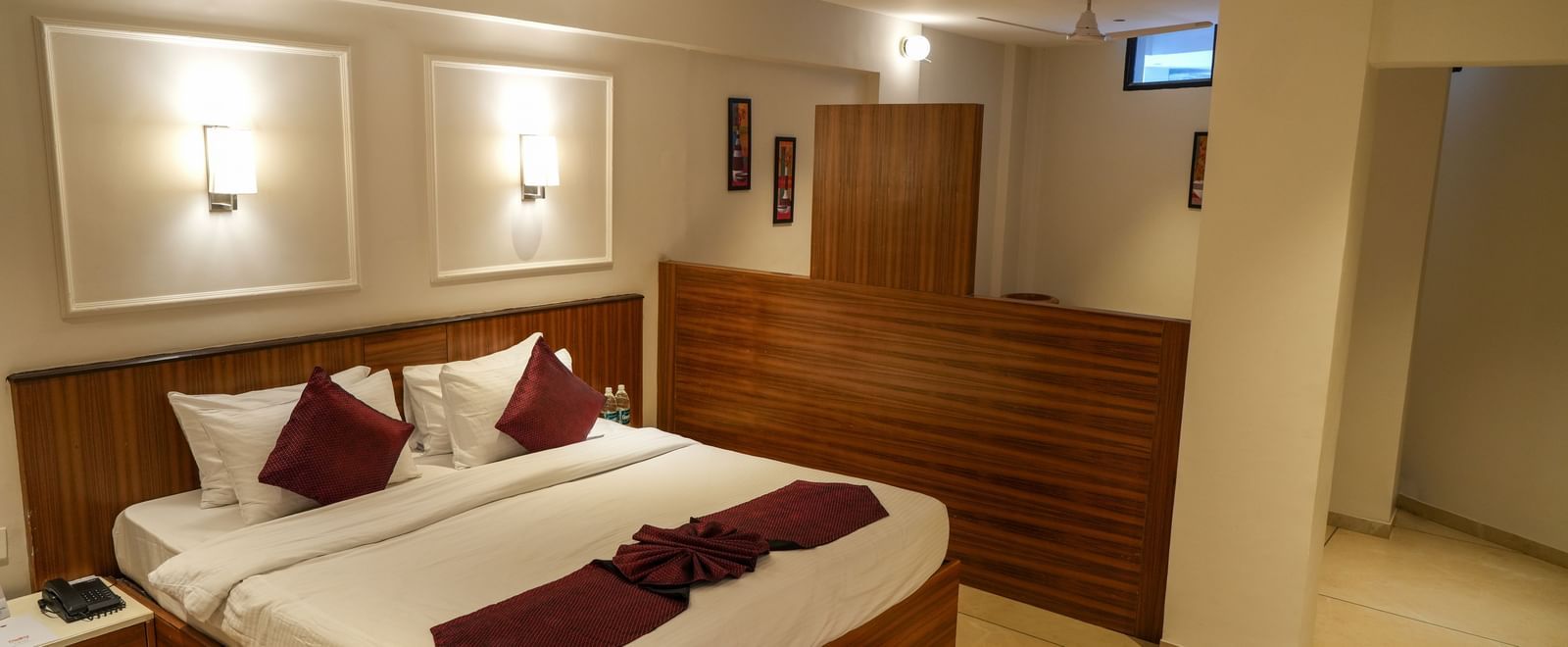 Spacious guest room with a large double bed and modern interiors at Pravasa Hotel Kolhapur.