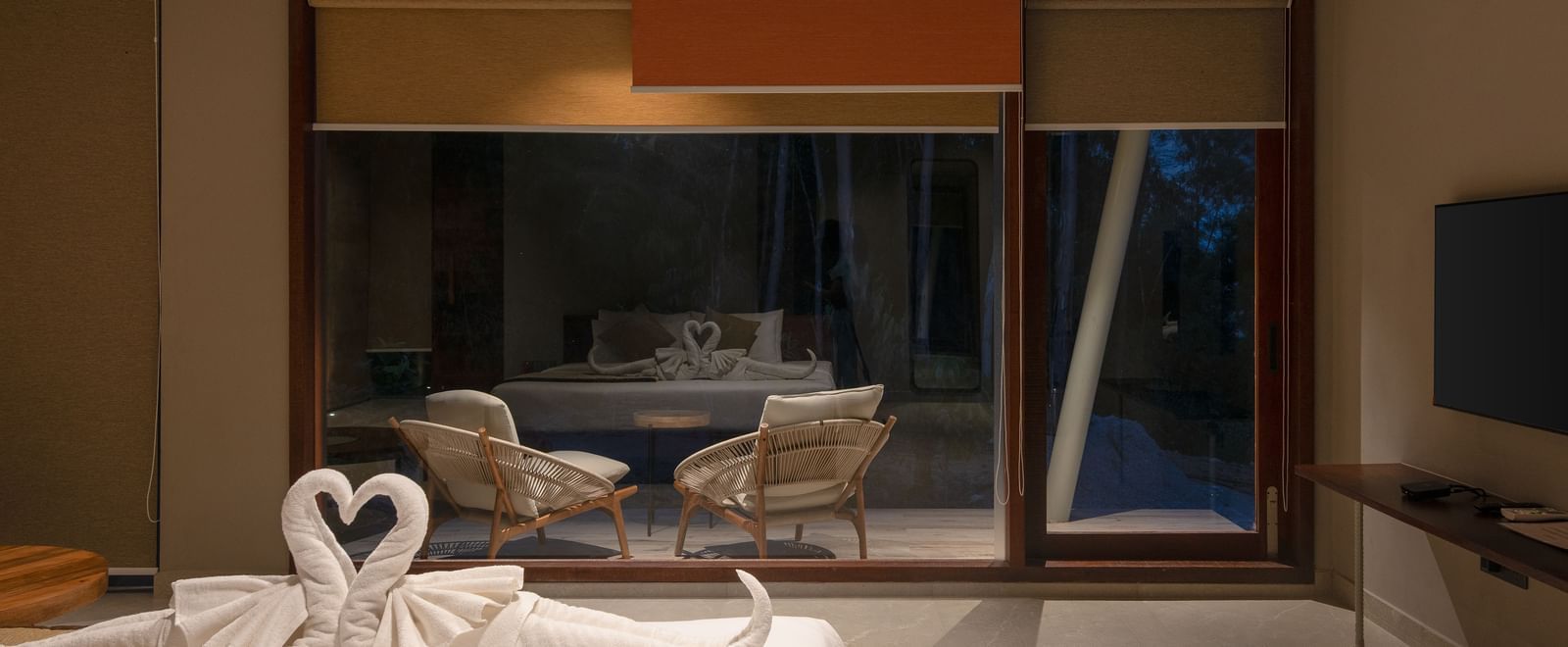 An interior shot of a contemporary living space with sleek furniture, a large glass door, and decorative elements | Gaia Studio | RD's Nature Retreat, Bangalore