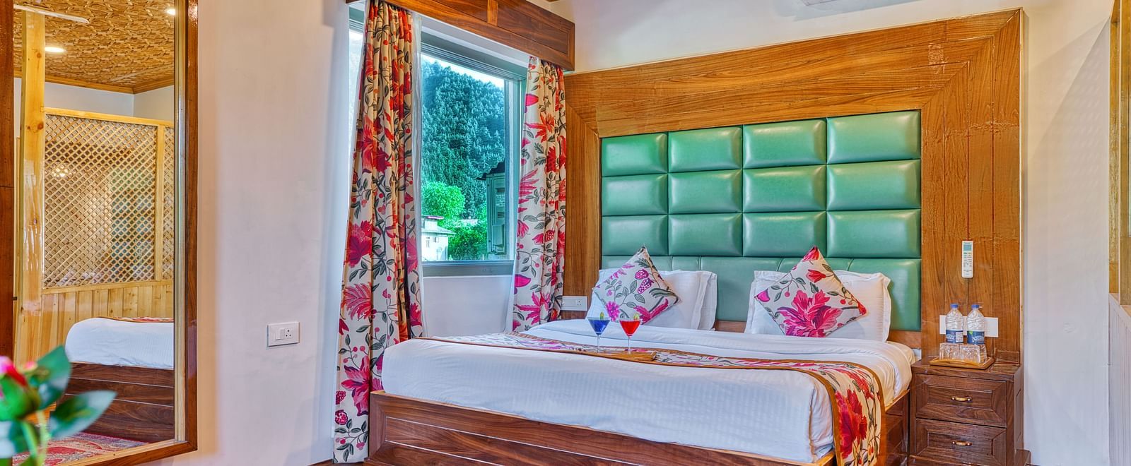 Stylish room with large mirror and window view at Royal Comfort Regency, offering elegance and a homely feel.