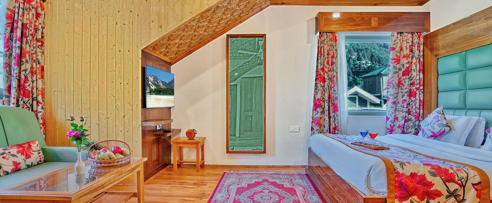 Traditional room at Royal Comfort Regency with wooden furniture, red carpet and large windows for natural light and charm.