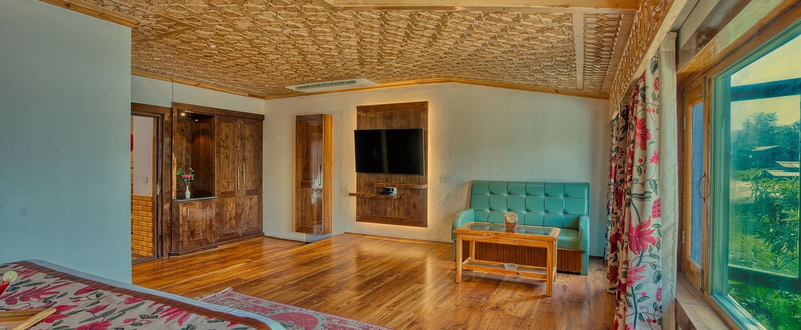 Open suite at Royal Comfort Regency with large windows, warm lighting and elegant wooden interiors for modern comfort.