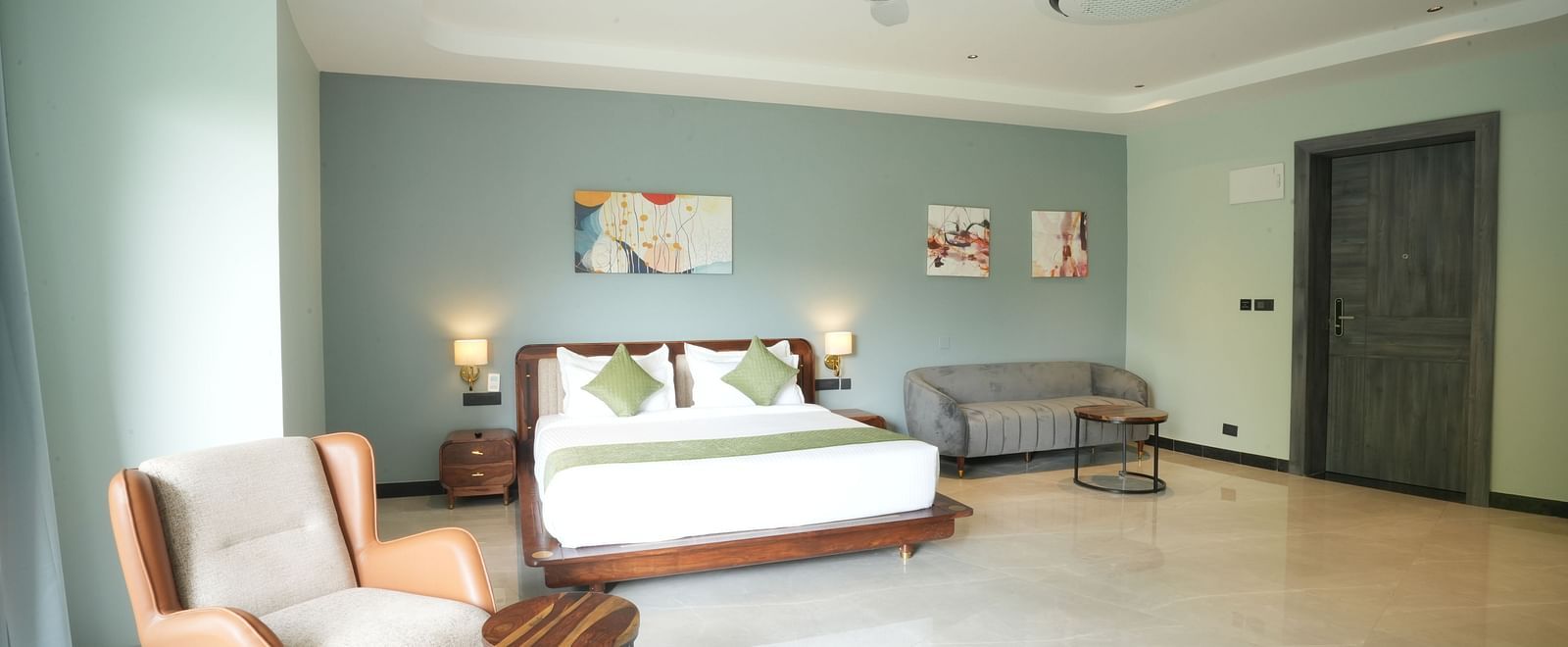 Club Suite with Valley View Sitout including a king size bed, seating area, and minimalist decor at The Qualia Resort Club & Brewery, Udaipur.