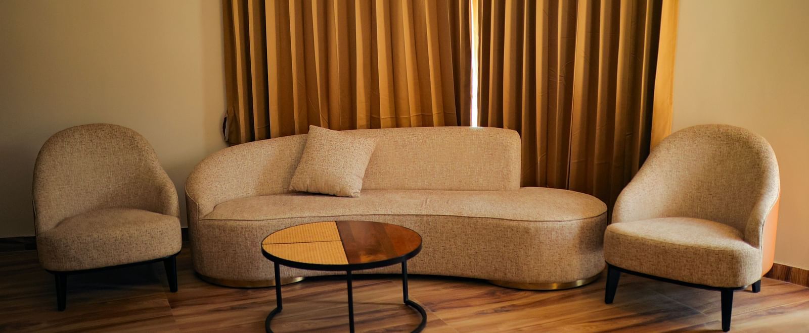 Luxury Villa with Plunge Pool featuring a lounge area with a sofa, chairs, and curtains, illuminated by warm lighting at The Qualia Resort Club & Brewery, Udaipur.