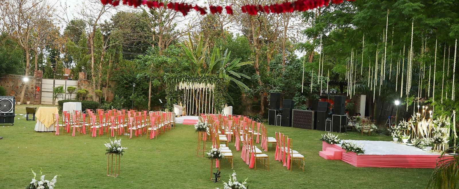 Lawn decorated for an outdoor function with floral canopy and seating at Tisya Farms, Gurgaon.