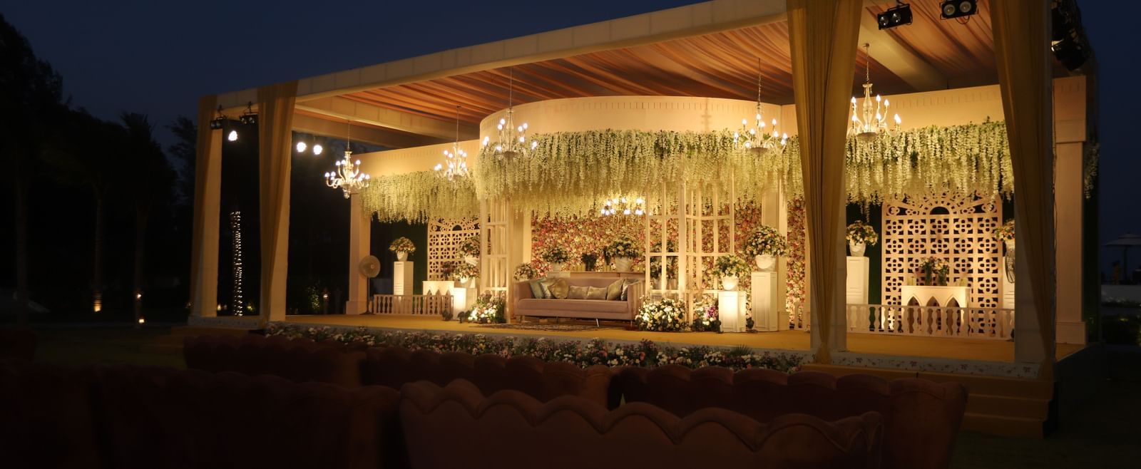 A mandap on the lawn of Kaldan Samudhra Palace featuring ornamental plants, a sofa and a chandelier 